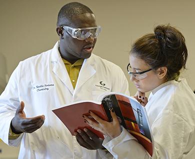 Chemistry professor and student discussing over textbook