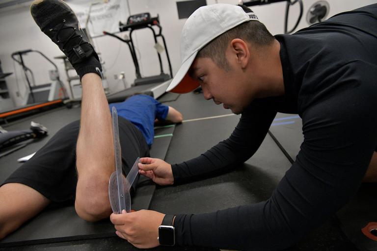 Exercise science student measuring knee flexibility