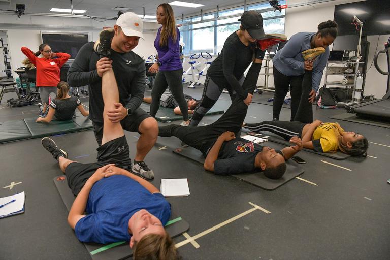 Exercise science students demonstrating leg stretches