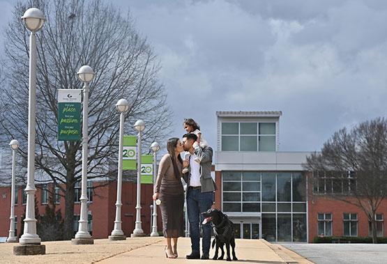 Valentina Velasquez shares a kiss with her husband, Esteban Gonzalez, as he carries their daughter, Antonella, while strolling through GGC with their dog, Belky