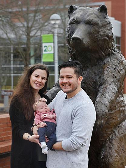 Natalie and Mauricio Zelada, with their daughter, Evelyn, pose together in front of General on Saturday, Feb. 8, 2025 at Georgia Gwinnett College. Natalie and Mauricio met at GGC during a Welcoming Celebration in 2012, began dating in 2015 and got married in 2018. Photo by Daniel Melograna/Georgia Gwinnett College