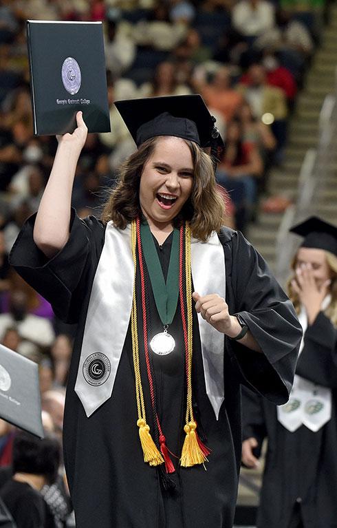 Female graduate celebrating diploma at commencement