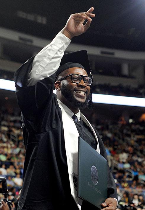 Male graduate waving at commencement