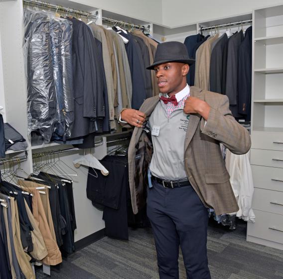 Male student selecting career-ready attire from the Lending Closet