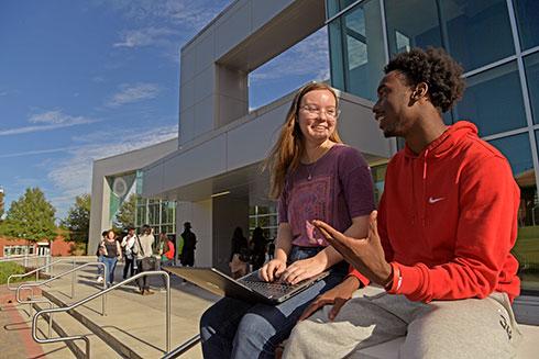 Students engaged in conversation outside library