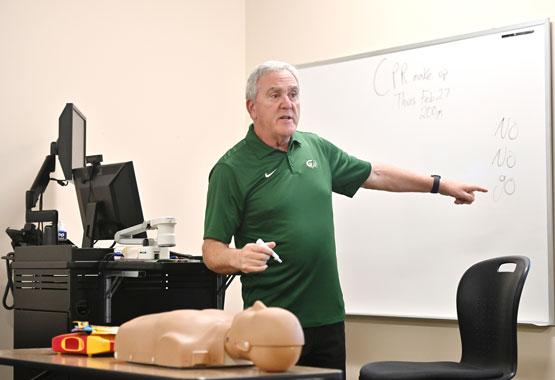 Dr. Kenneth Horowitz, assistant professor of physical education at GGC, gestures to the classroom whiteboard as he explains the rules students should consider before performing CPR: "No, No, Go."