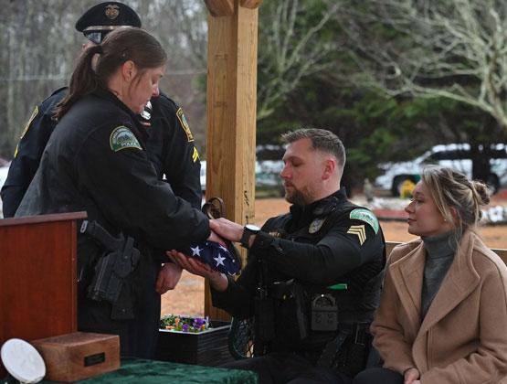 Captain Rebecca Lawler presents Sgt. Chris Wragg the American flag during Officer Buddy's funeral at the Pet Angel Memorial Center in Bethlehem, GA.