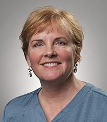 Dr. Karen Benson wearing a blue blouse and smiling at camera