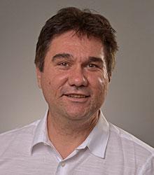 Dr. Boyko Gyurov wearing a white shirt and smiling at camera