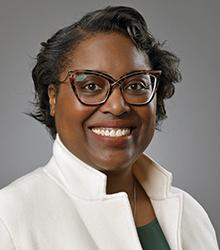 Dr. Alesha Harris wearing glasses and smiling at camera