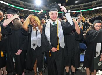 Male and female students turning the tassels on their graduation caps