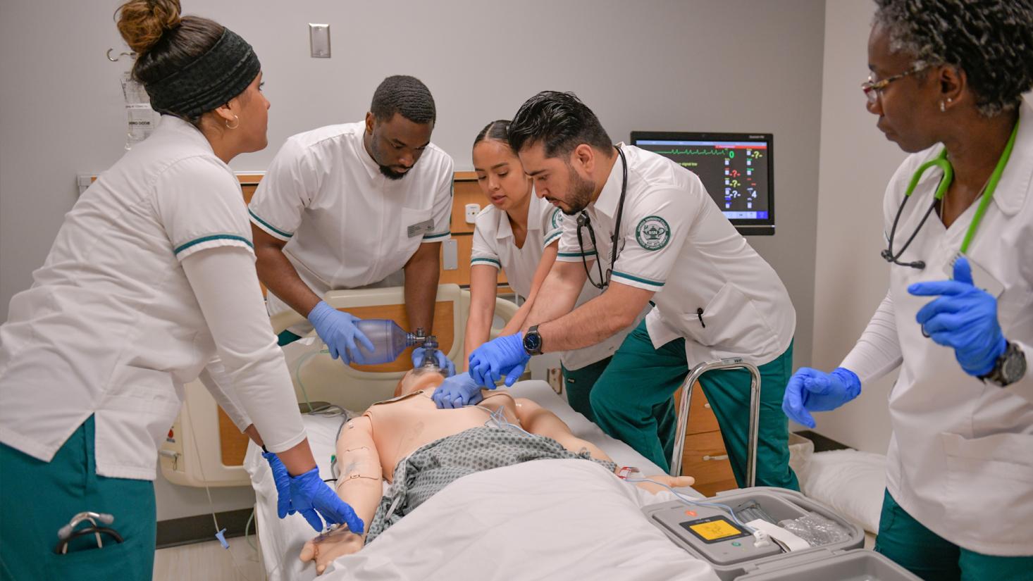 male and female nursing students practicing CPR on a mannequin