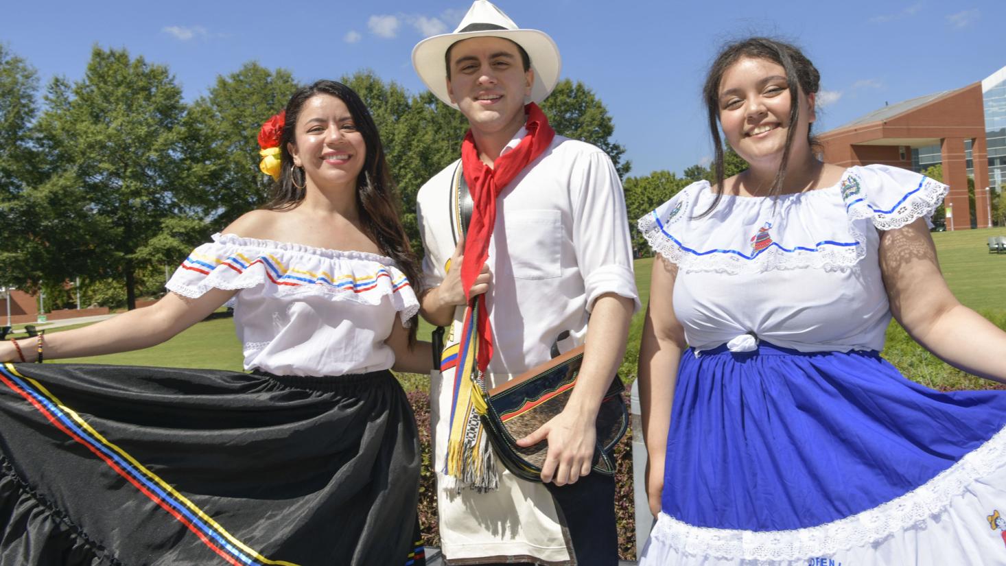 A man and two women wearing cultural clothing