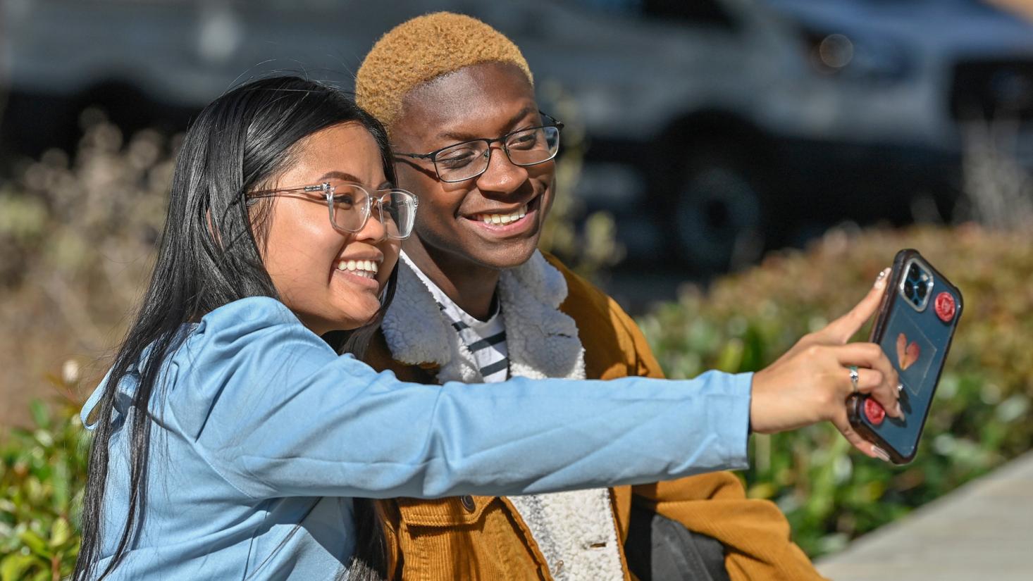 Students taking a photo of themselves using a cell phone