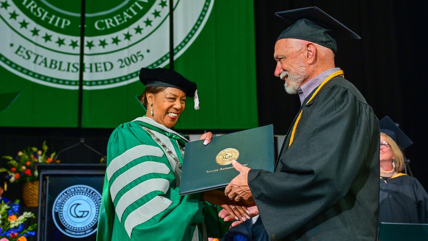 Graduate receiving diploma from GGC president