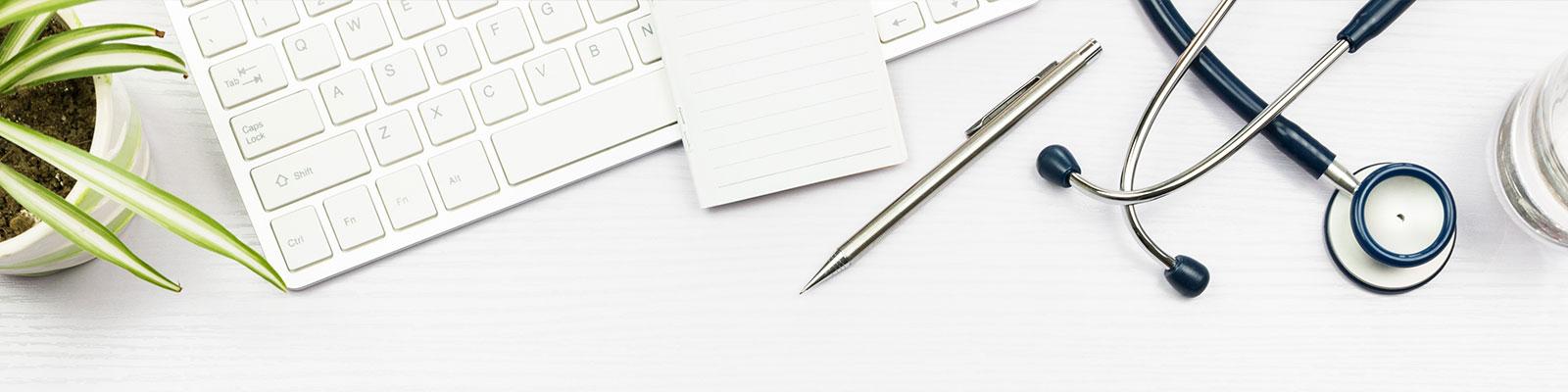 desktop with plant, computer keyboard, stethoscope, pen desktop with plant, computer keyboard, stethoscope, pen