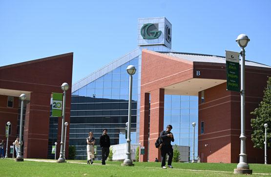 GGC student walking in front of GGC's signature Building B